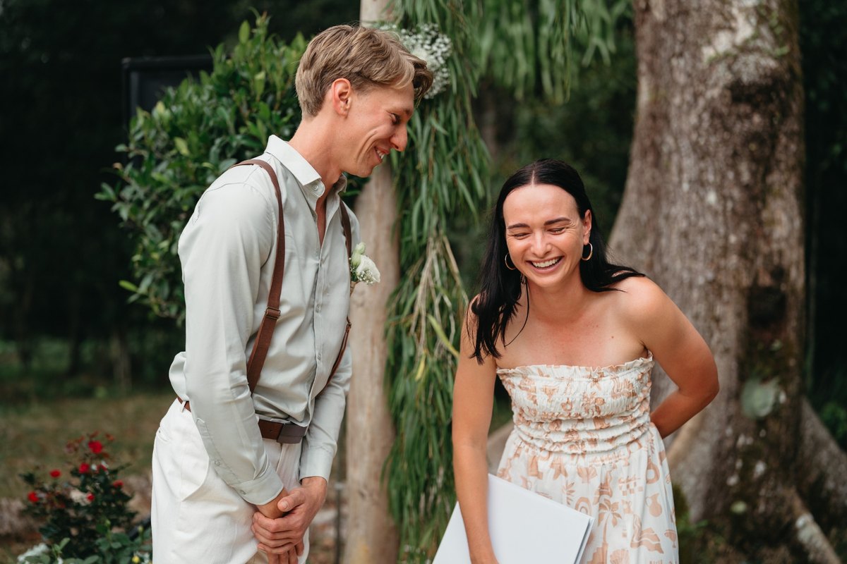 Ashley and the groom laughing during an outdoor wedding ceremony